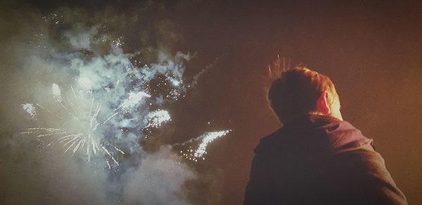 Rear view of boy with arms raised