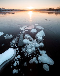 Scenic view of frozen lake against sky during sunset