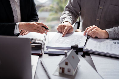 Midsection of business people working on table