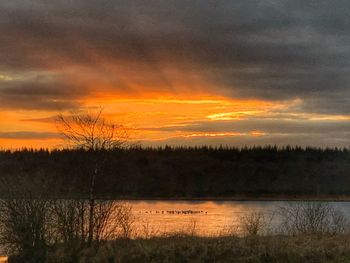 Scenic view of lake against orange sky