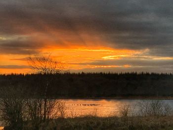 Scenic view of lake against orange sky