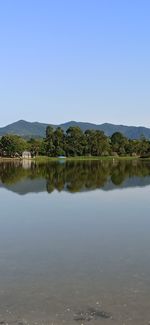 Scenic view of lake against clear blue sky