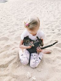 Girl sitting on sand at beach