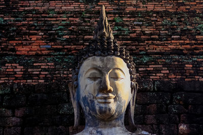 Close-up of statue against brick wall