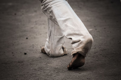 Low section of man walking on road