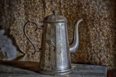 Old metallic teapot on table