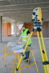 Surveyor engineer working at construction site with measuring equipment (total station)