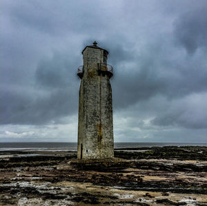Low angle view of tower on field against sky