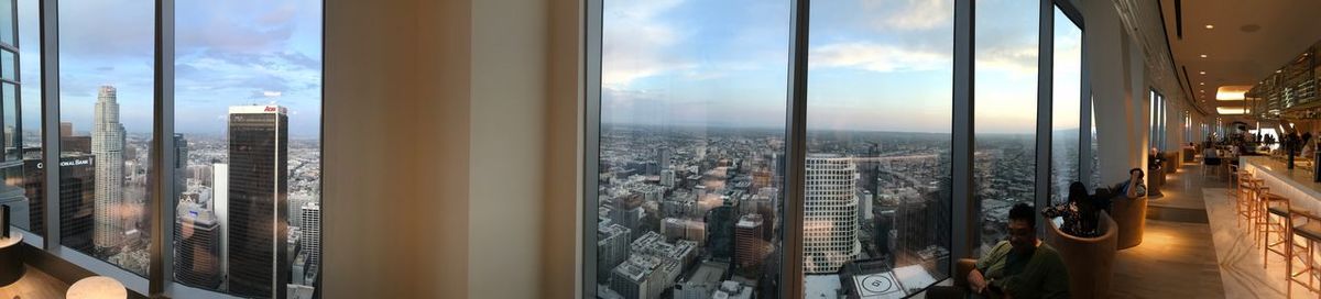 Panoramic view of cityscape against sky seen through window
