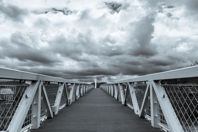 Empty footbridge against sky