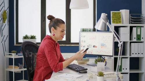 Businesswoman using smart phone at office