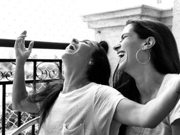 Female friends laughing while standing outdoor