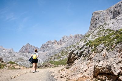 Rear view of a woman hiking in rocky mountains