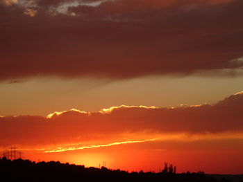 Scenic view of silhouette mountains against orange sky