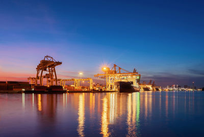 Commercial dock at sea against sky during dusk