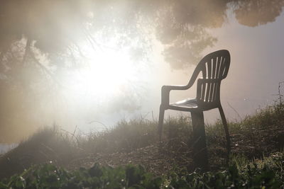 View of chair on landscape against sky