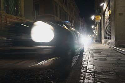 Cars on illuminated street in city at night