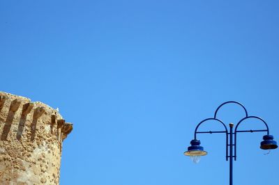 Low angle view of street light against clear blue sky