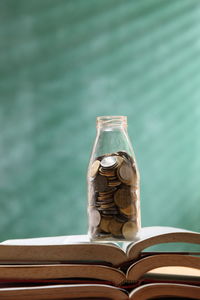Close-up of coins in bottle on books