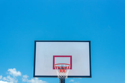 Low angle view of basketball hoop against blue sky