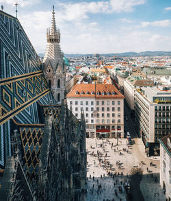 High angle view of city buildings against cloudy sky