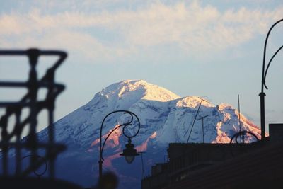 Low angle view of snow covered mountain against sky