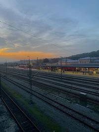 Train at railroad station against sky during sunset