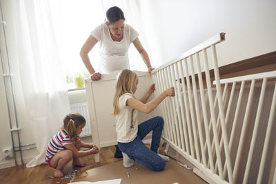 Mother and daughters building cot