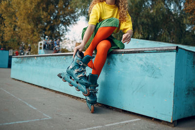 Low section of woman wearing skates at park