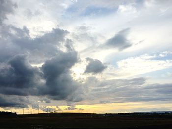 Scenic view of field against cloudy sky