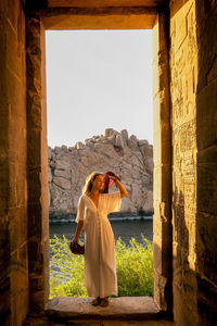 Front view of woman standing against old building