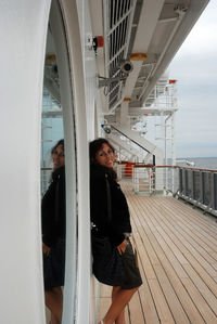 Portrait of young woman smiling while standing on boat