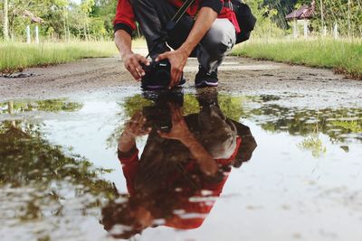 Low section of man with reflection in puddle