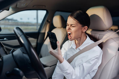 Portrait of young woman driving car