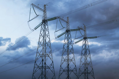 Low angle view of electricity pylon against sky