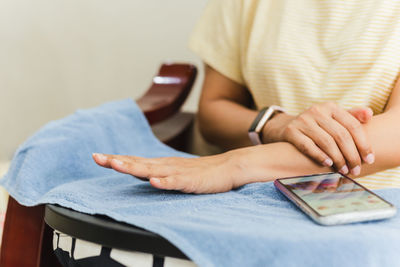 Midsection of woman using mobile phone while sitting on sofa at home