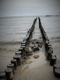 Wooden posts leading into the sea