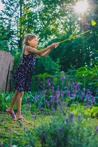 Low angle view of woman standing by flowering plants