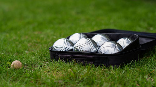 Petanque set with six metal balls in a black case on green grass. play in your own garden.