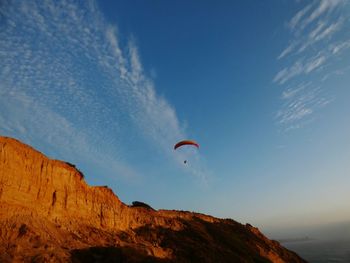 Low angle view of person paragliding against sky