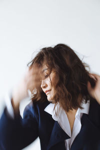 Young woman looking away against white background