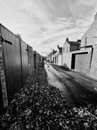 Surface level of footpath amidst buildings against sky