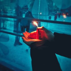 Close-up of hand holding lit candle