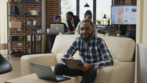 Portrait of smiling businessman sitting at office