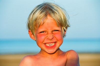 Close-up portrait of cheerful shirtless boy