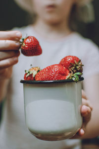 Close-up of hand holding strawberries