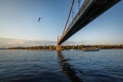 Bridge over river against sky during sunset