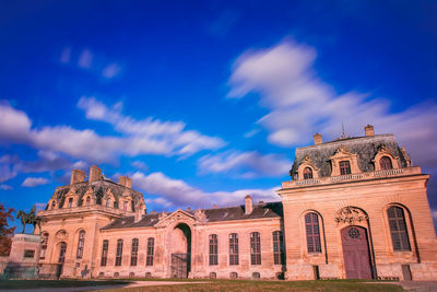 Low angle view of historic building against blue sky