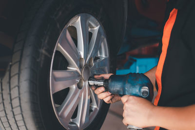 Cropped hand of mechanic repairing car