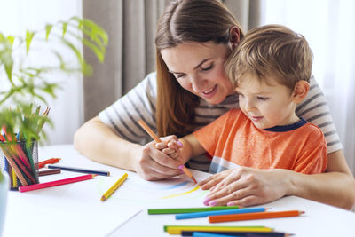 Sisters drawing on book at home